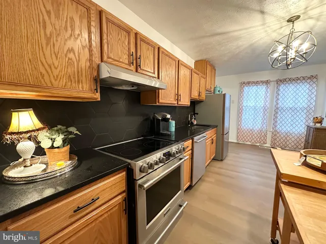 a kitchen with stainless steel appliances granite countertop a stove a sink and cabinets