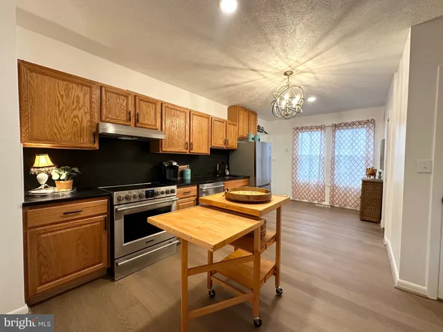 a kitchen with stainless steel appliances a stove a refrigerator and a microwave