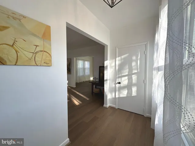 a view of a hallway with wooden floor and a livingroom