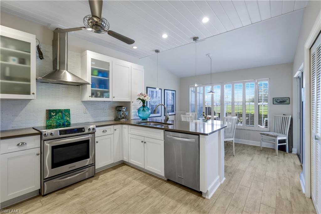 11831 Quail Village Way Naples, FL 34119 - Photo 11 of 32 a kitchen with stainless steel appliances granite countertop a stove and cabinets