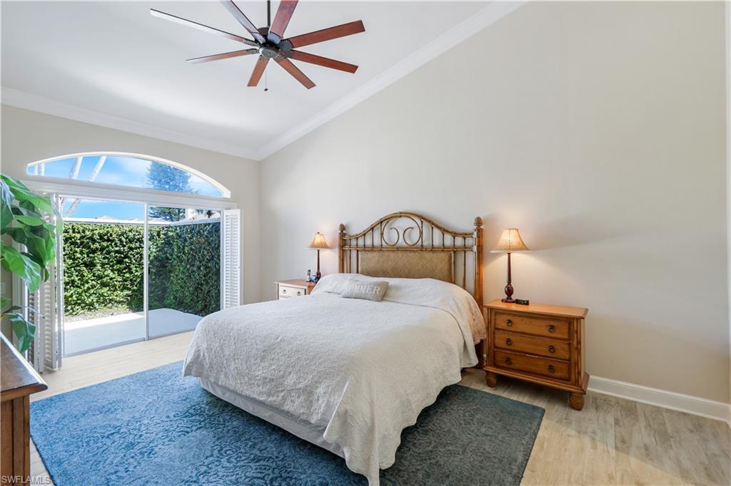 11831 Quail Village Way Naples, FL 34119 - Photo 15 of 32 a bedroom with a bed a mirror and a large window