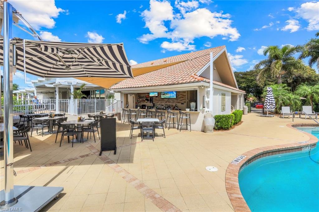 11831 Quail Village Way Naples, FL 34119 - Photo 26 of 32 a view of a patio with a table and chairs and potted plants