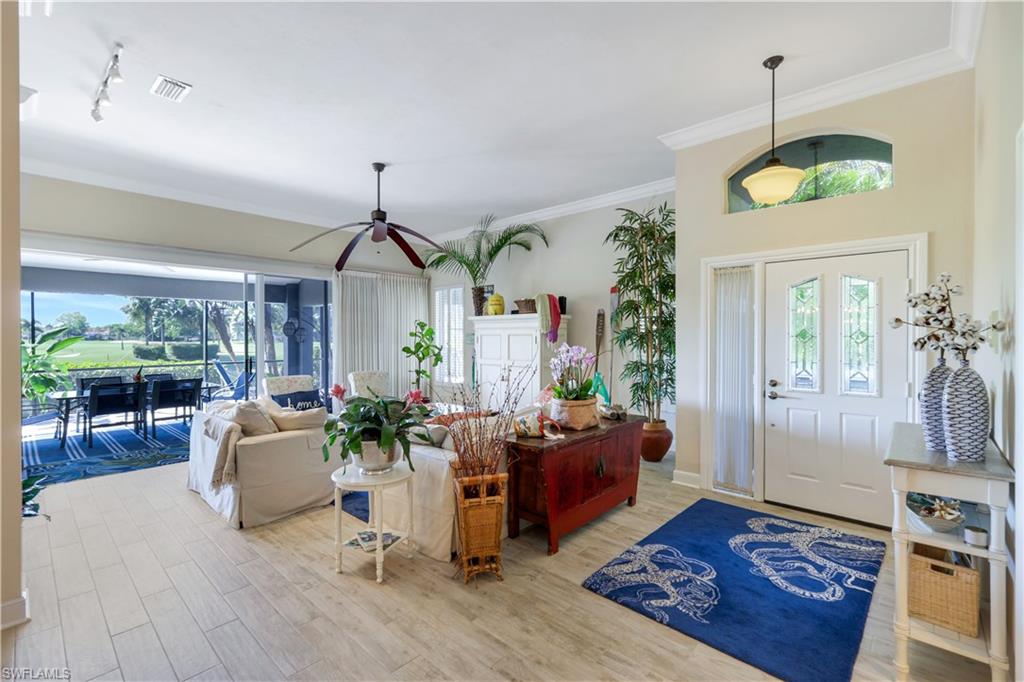 11831 Quail Village Way Naples, FL 34119 - Photo 4 of 32 a living room with furniture and wooden floor