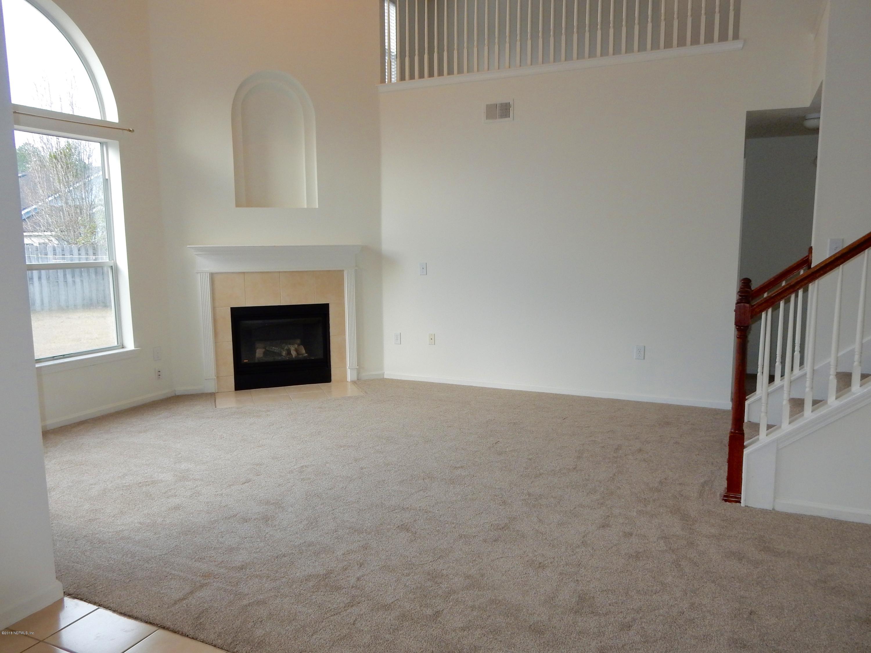 1528 Summerdown Way St. Johns, FL 32259 - Photo 14 of 28 a view of an empty room with a fireplace and a window
