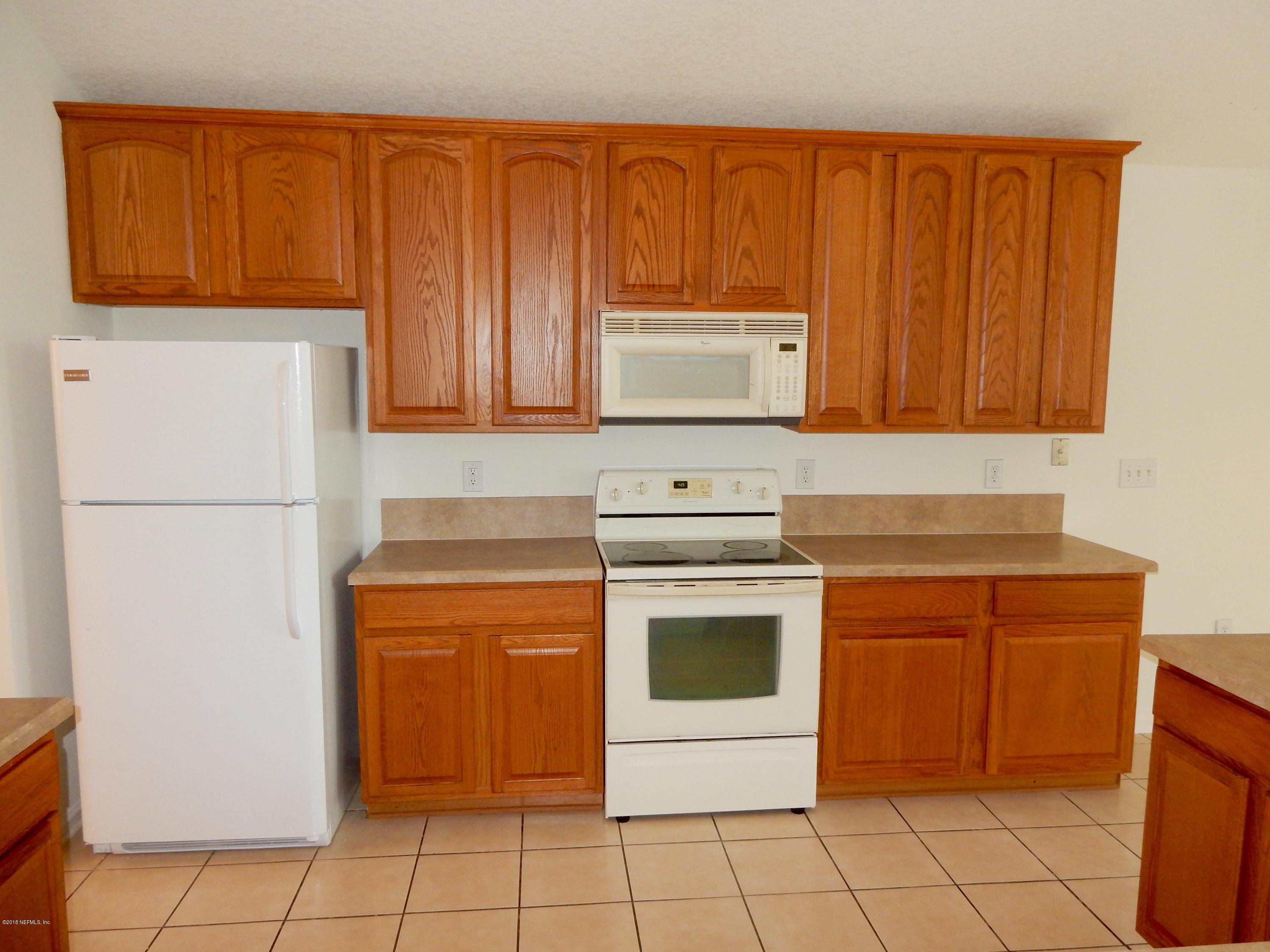 1528 Summerdown Way St. Johns, FL 32259 - Photo 6 of 28 a kitchen with a stove top oven and cabinets