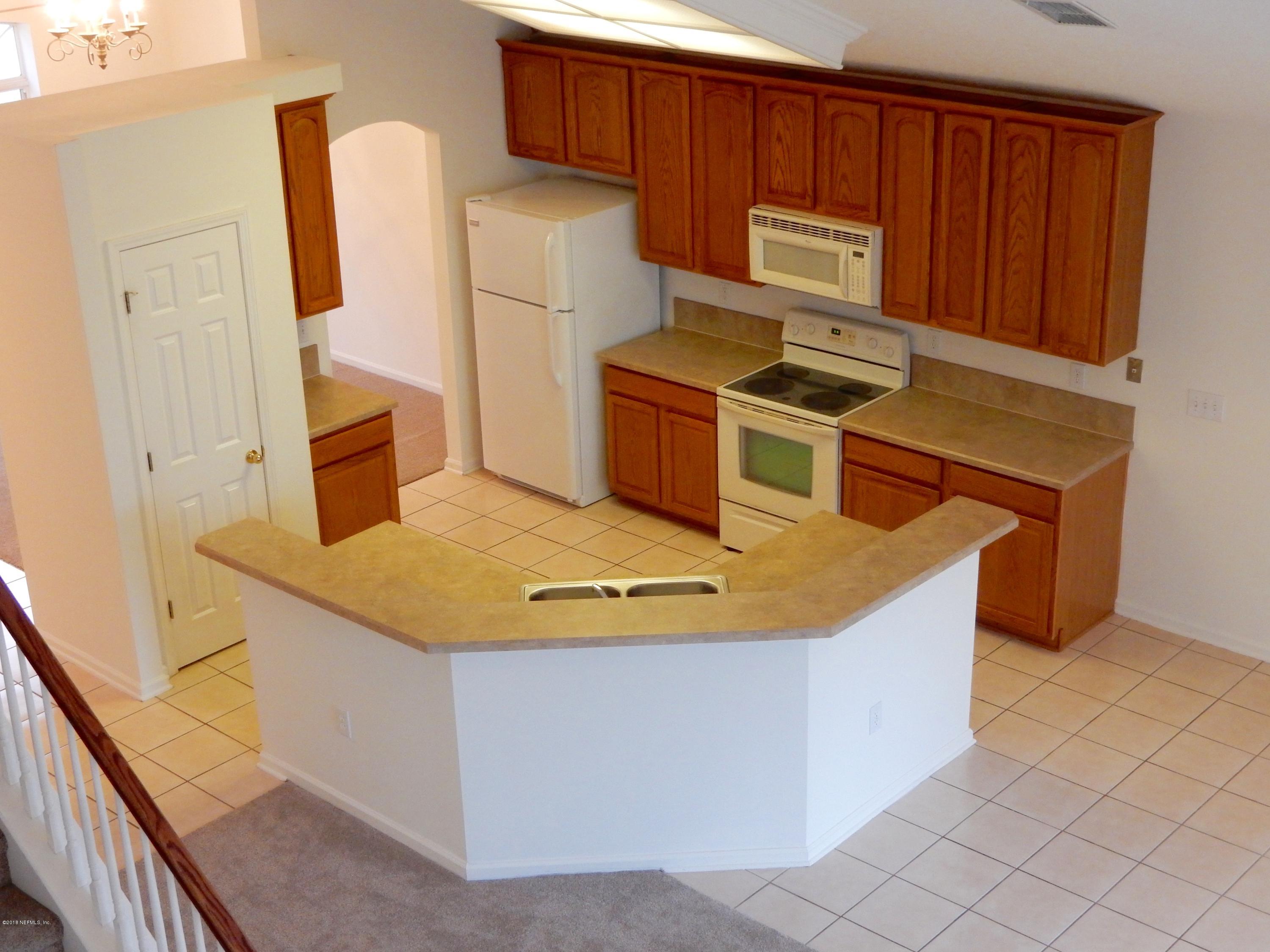 1528 Summerdown Way St. Johns, FL 32259 - Photo 8 of 28 a kitchen with wooden cabinets a sink a stove and a refrigerator