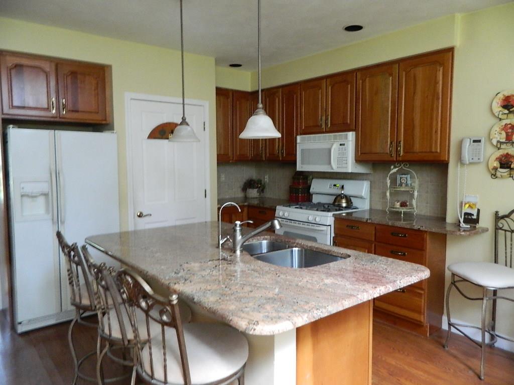 4619 Spring Brook Road Rockford, IL 61114 - Photo 3 of 32 a kitchen with granite countertop a table chairs stove and cabinets