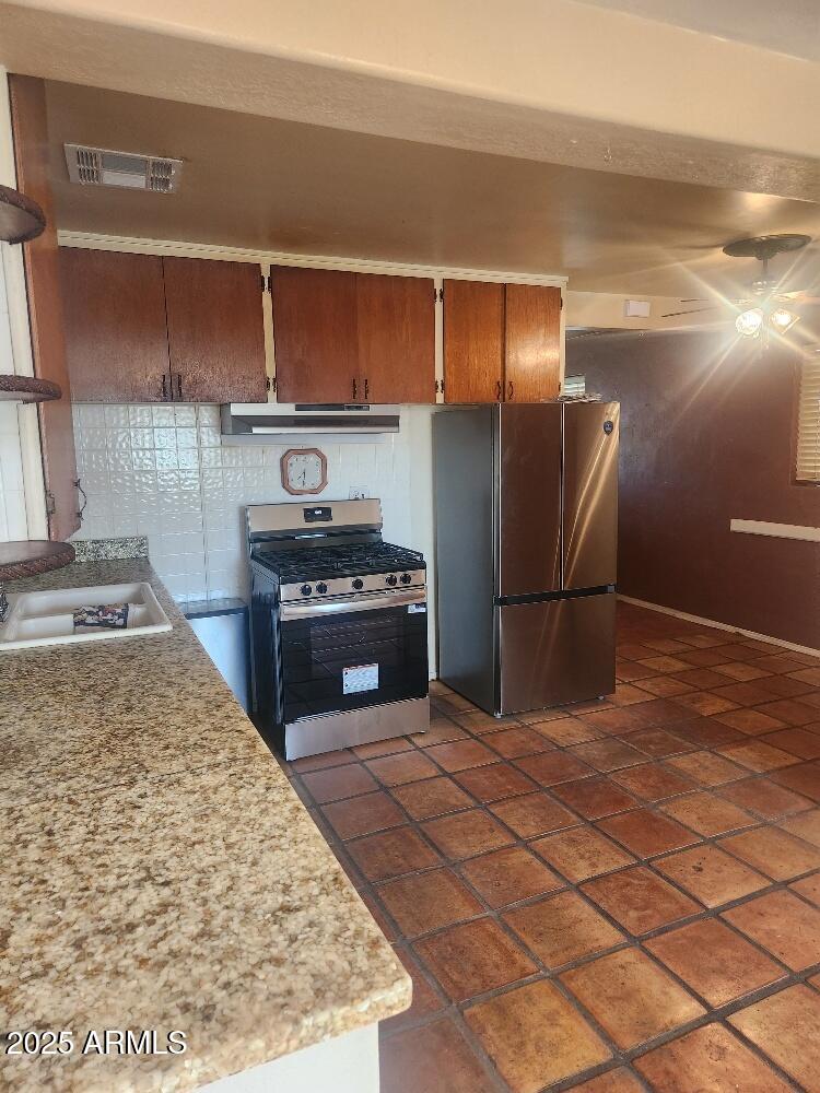 7 East Beautiful Lane Phoenix, AZ 85042 - Photo 25 of 26 a kitchen with stainless steel appliances granite countertop a refrigerator and a stove