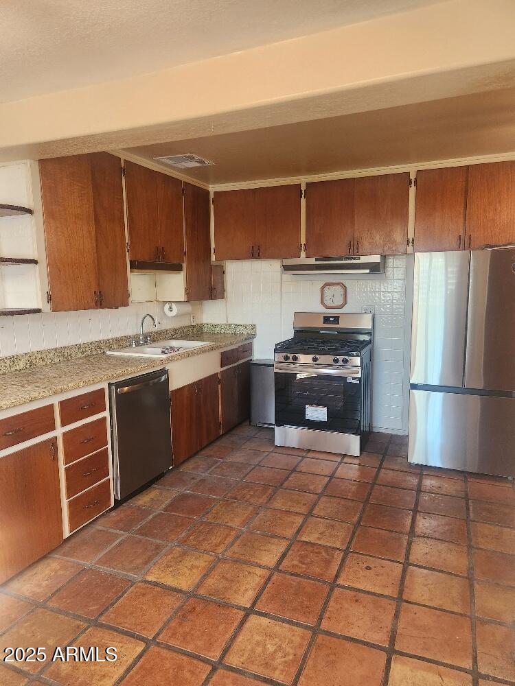 7 East Beautiful Lane Phoenix, AZ 85042 - Photo 7 of 26 a kitchen with stainless steel appliances granite countertop a stove a sink dishwasher and a refrigerator