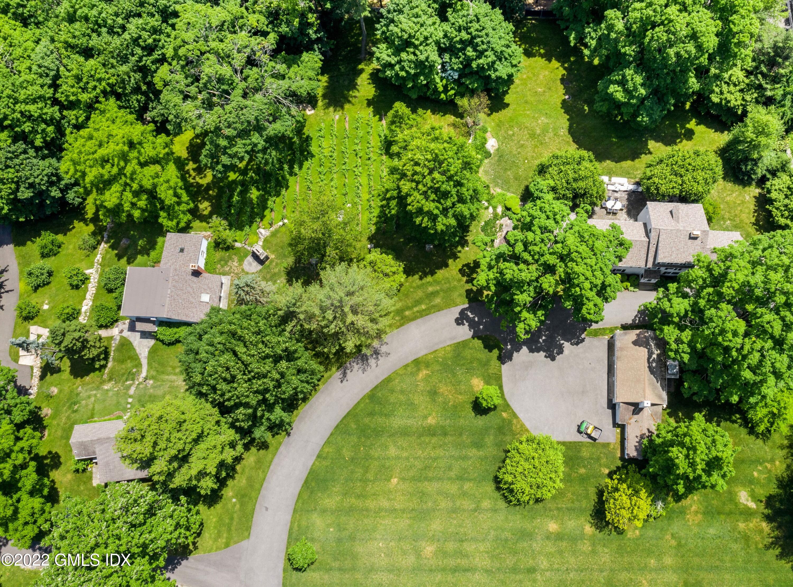 an aerial view of a house with a yard and trees all around