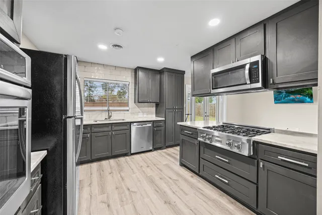 a kitchen with stainless steel appliances granite countertop a stove a sink and a refrigerator