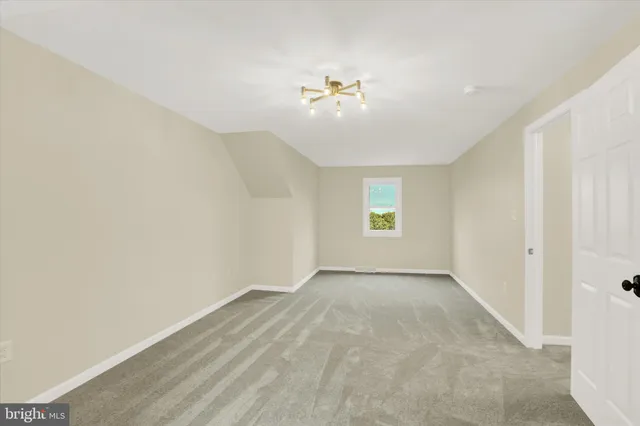 an empty room with windows and chandelier fan