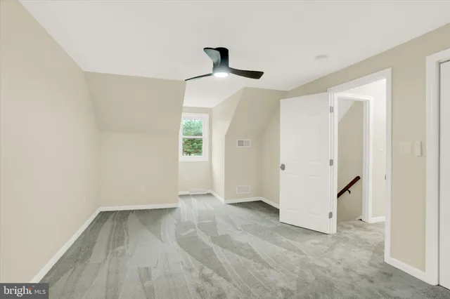 an empty room with a ceiling fan and entryway