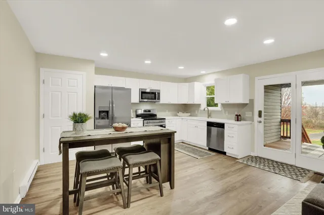 a kitchen with white cabinets and stainless steel appliances