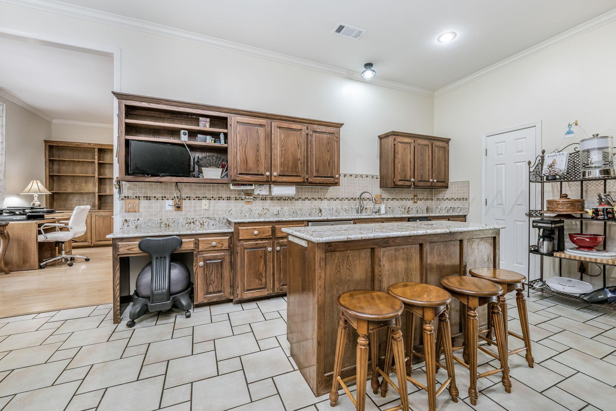7809 Bent Tree Drive Amarillo, TX 79121 - Photo 10 of 31 a kitchen with stainless steel appliances kitchen island granite countertop a stove a sink a microwave and a refrigerator