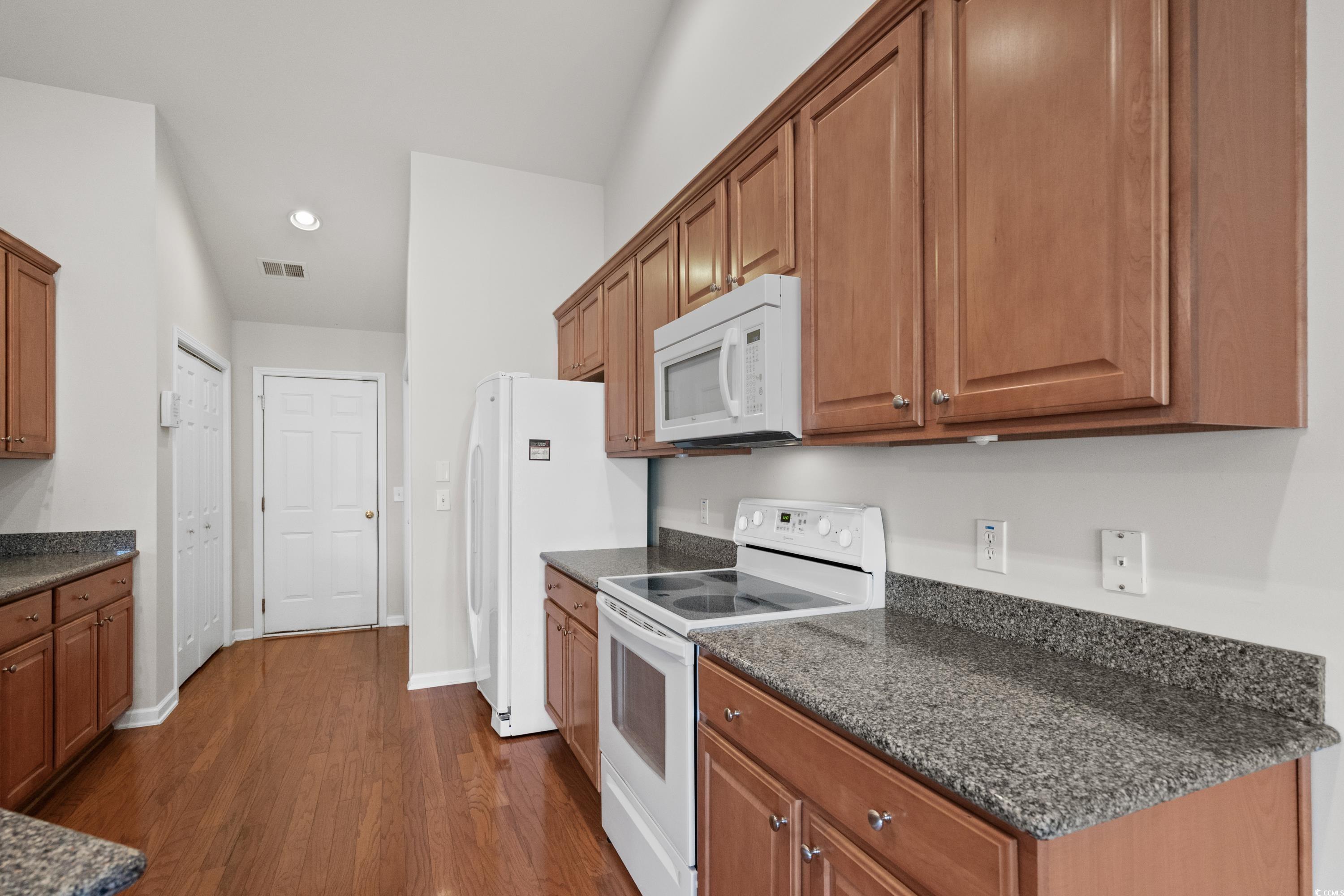 346 Whitchurch Street Murrells Inlet, SC 29576 - Photo 16 of 34 Kitchen with brown cabinets, baseboards, white app