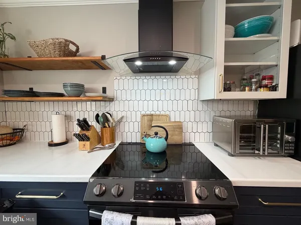 a kitchen with a stove and a wooden floor
