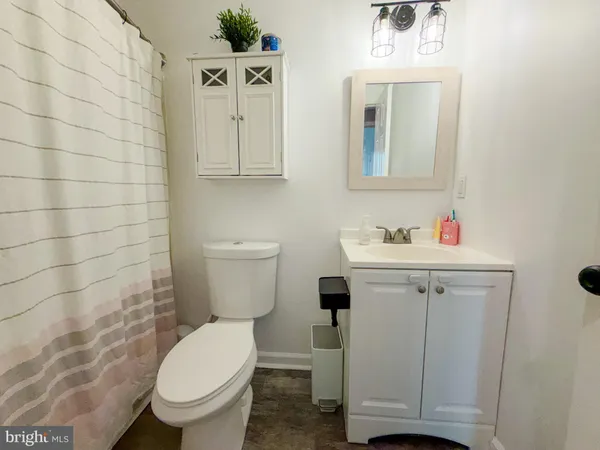 a bathroom with a toilet sink vanity and mirror