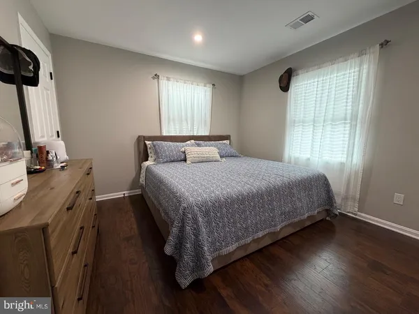 a bedroom with a bed window and wooden floor