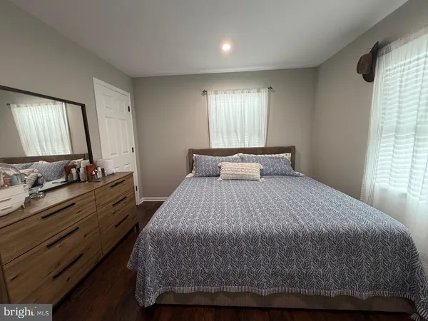 a bedroom with a bed and a dresser with mirror