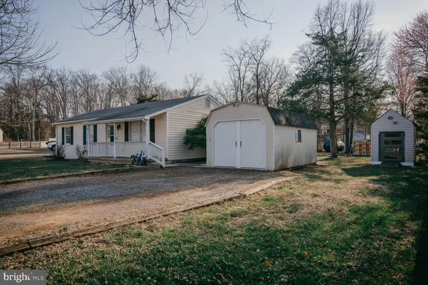 a backyard of a house with wooden fence and large trees