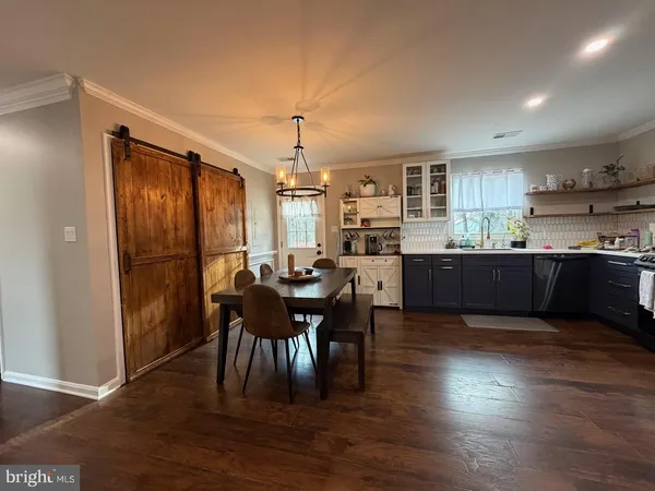 a kitchen with stainless steel appliances granite countertop dining table chairs and wooden floor