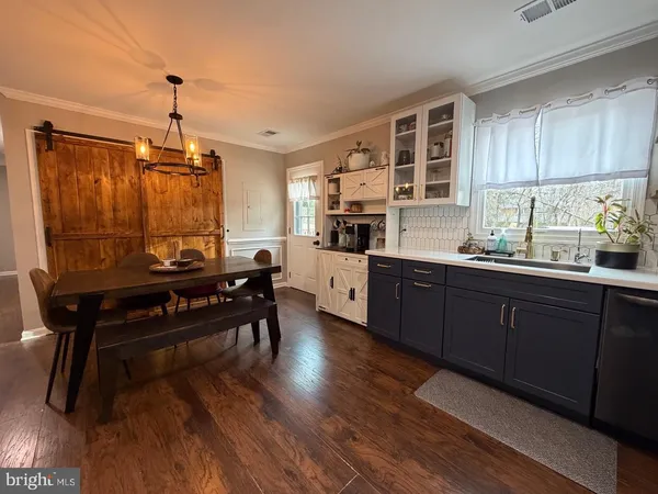 a kitchen with sink cabinets and wooden floor