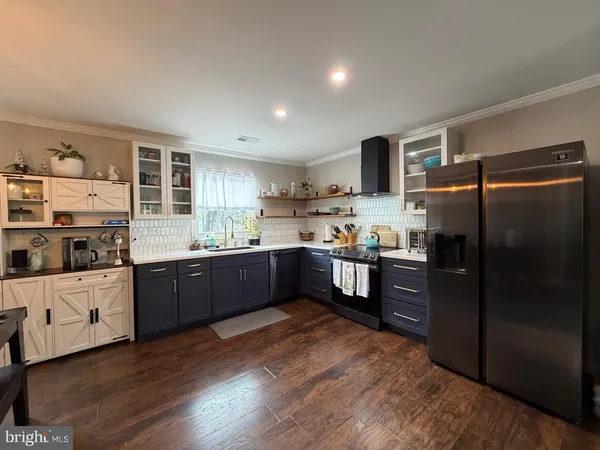 a kitchen with granite countertop a refrigerator and wooden cabinets