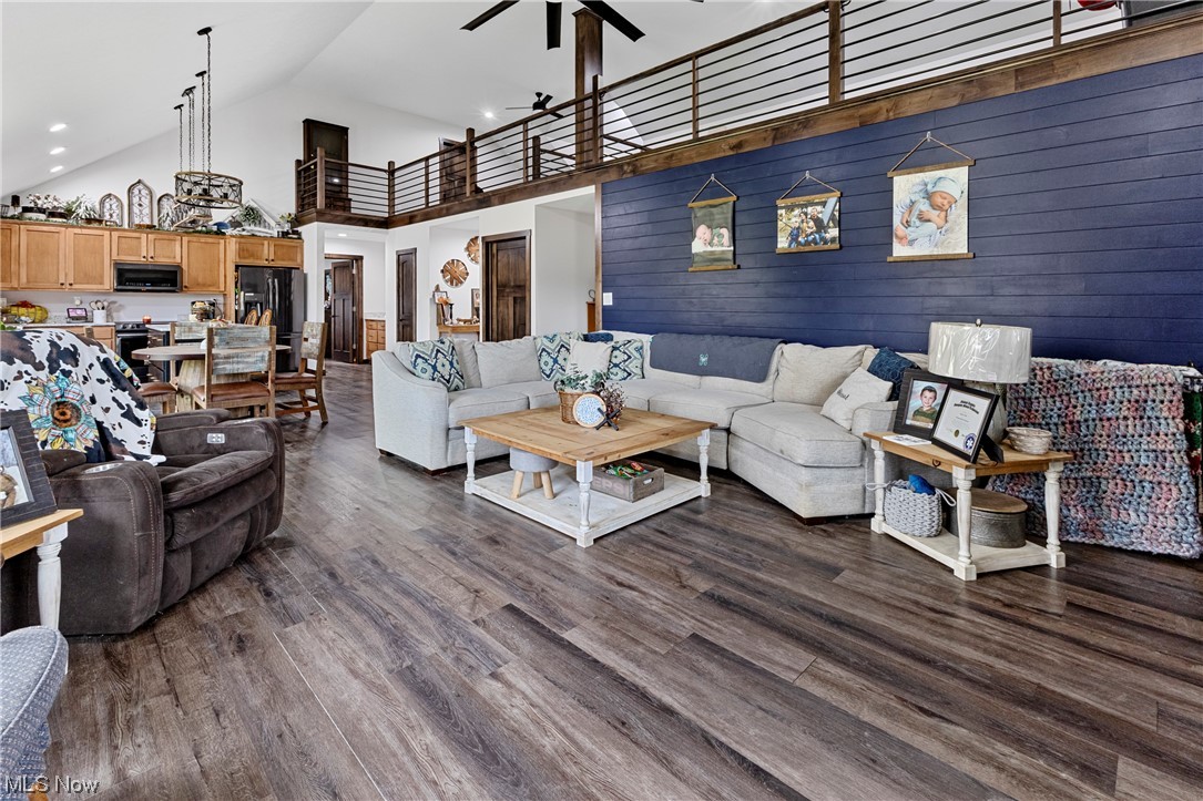 45588 County Road Cadiz, OH 43907 - Photo 12 of 35 Living room featuring dark hardwood / wood-style flooring, high vaulted ceiling, ceiling fan, and wooden shiplap accent wall.