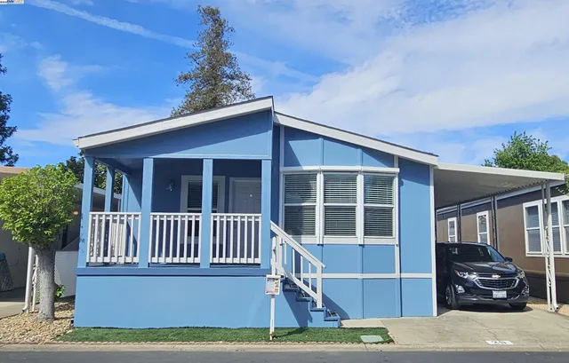 a view of a house with a deck and a yard