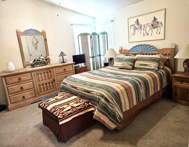a spacious bedroom with a bed and dresser