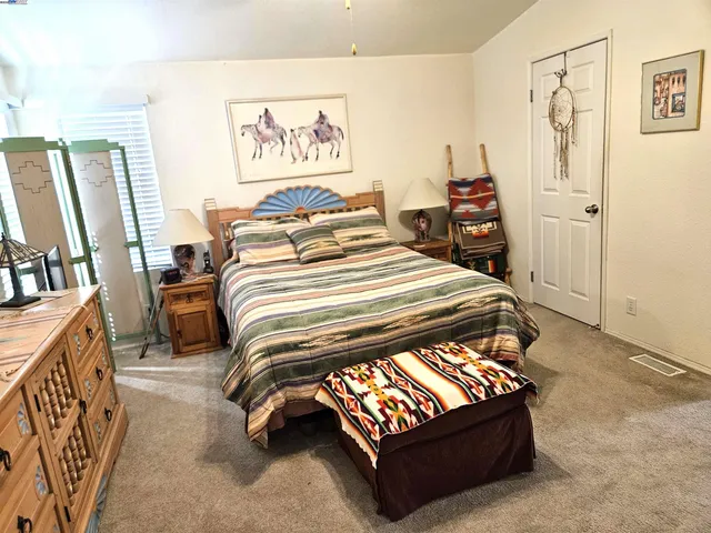 a bedroom with a bed a couch and a large mirror