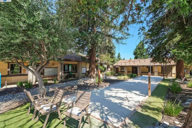 a view of a patio with a table and chairs under an umbrella