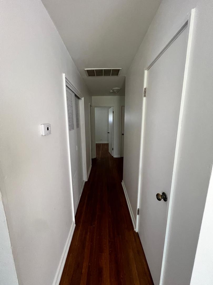 16442 Honore Avenue Markham, IL 60428 - Photo 11 of 16 a view of a hallway with wooden floor and staircase