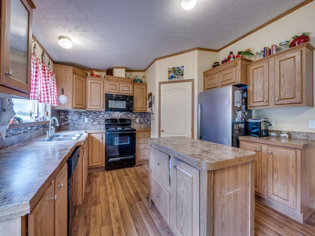 3517 Sandusky Road Whitesboro, TX 76273 - Photo 5 of 19 a kitchen with granite countertop a sink stove and refrigerator