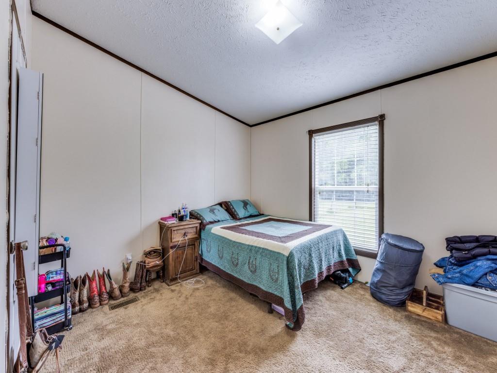 3517 Sandusky Road Whitesboro, TX 76273 - Photo 8 of 19 a room with a bed a standing and a desk