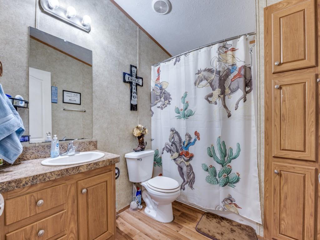 3517 Sandusky Road Whitesboro, TX 76273 - Photo 10 of 19 a bathroom with a granite countertop sink toilet and a mirror
