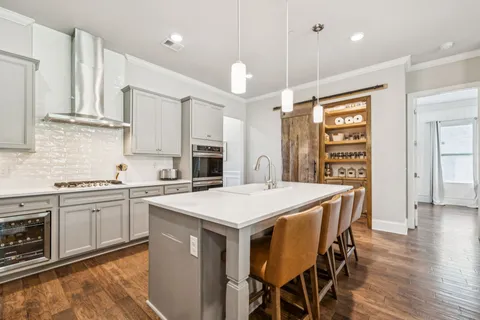 a kitchen with stainless steel appliances white cabinets and a stove top oven