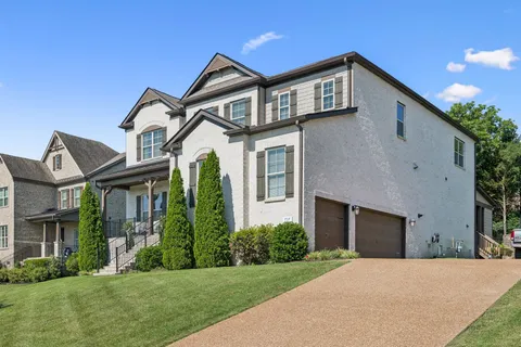 a front view of a house with a yard and trees
