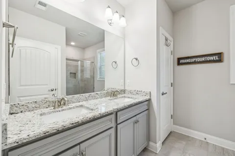 a bathroom with a granite countertop sink a toilet and shower