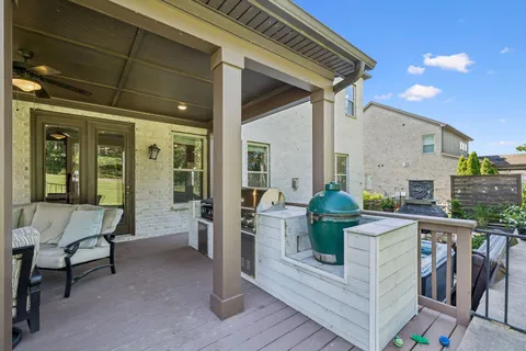a view of a patio with couches and a table and chairs with wooden fence
