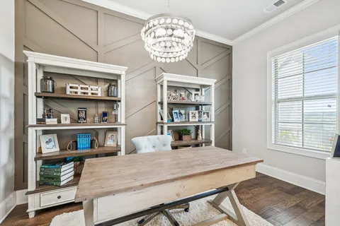 a view of a dining room with furniture a chandelier and wooden floor