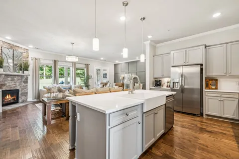 a kitchen with stainless steel appliances granite countertop a stove top oven a sink refrigerator and white cabinets