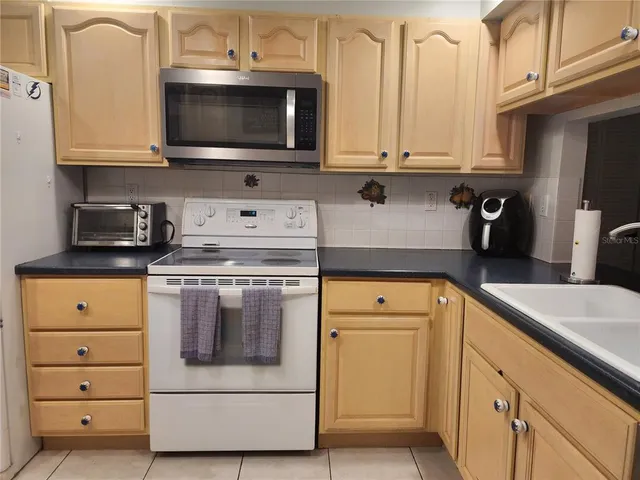 a kitchen with granite countertop white cabinets stainless steel appliances and sink