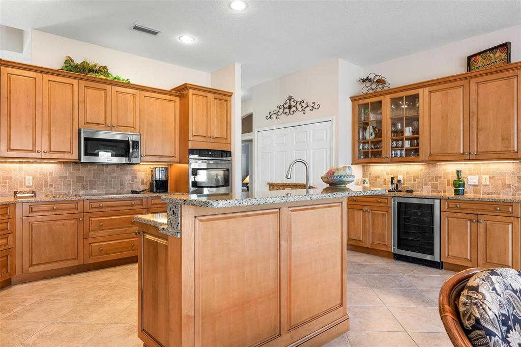 433 Tremingham Way Venice, FL 34293 - Photo 19 of 95 a kitchen with stainless steel appliances granite countertop a stove top oven a sink a refrigerator and a microwave