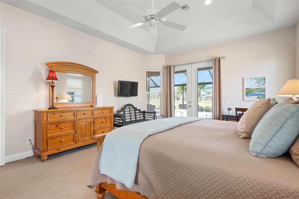 433 Tremingham Way Venice, FL 34293 - Photo 34 of 95 a bedroom with a bed and dresser with mirror