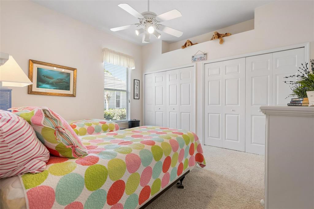 433 Tremingham Way Venice, FL 34293 - Photo 38 of 95 a bedroom with a bed and a chandelier