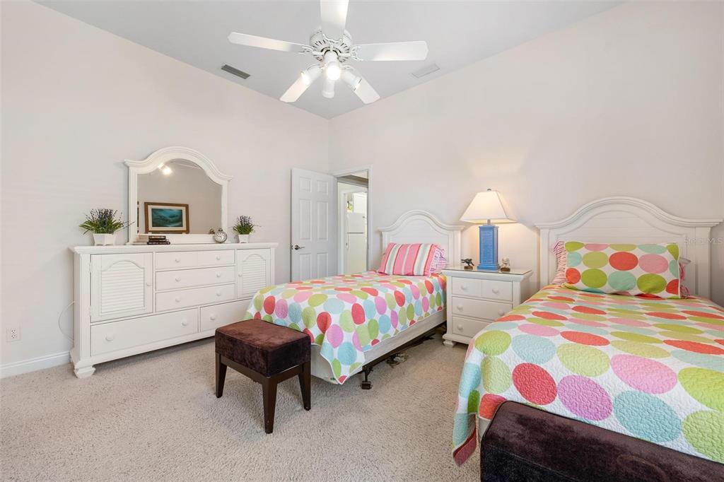 433 Tremingham Way Venice, FL 34293 - Photo 40 of 95 a bedroom with two beds and a chandelier
