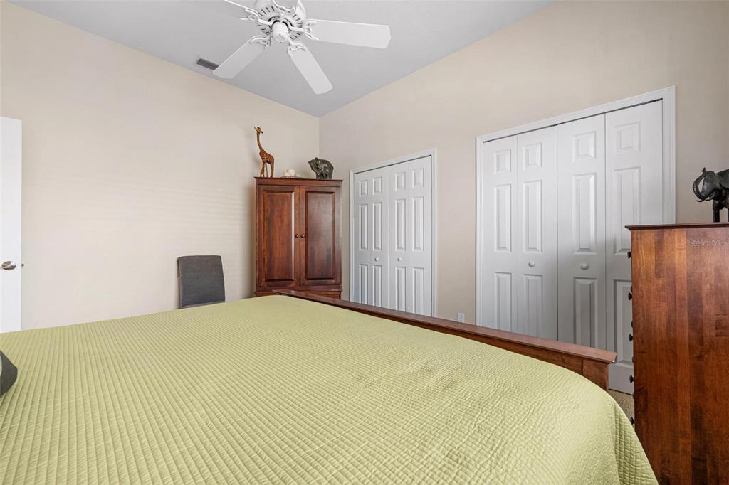 433 Tremingham Way Venice, FL 34293 - Photo 43 of 95 a bedroom with a bed and a chandelier