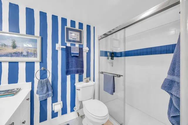 a white toilet sitting next to a bathroom sink and a mirror